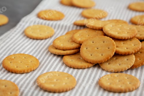 Preview: Round Crispy Crackers with Sea Salt on a gray background, side view.