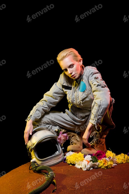 Preview: stylish cosmonaut in spacesuit with flowers and helmet sitting on planet
