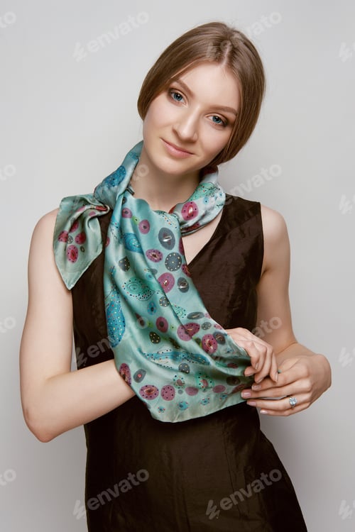 Preview: Attractive girl in slim dress and colorful silk scarf posing on pink background