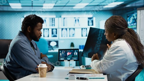 Preview: Black male patient bringing x ray test results to medic for scan interpretation