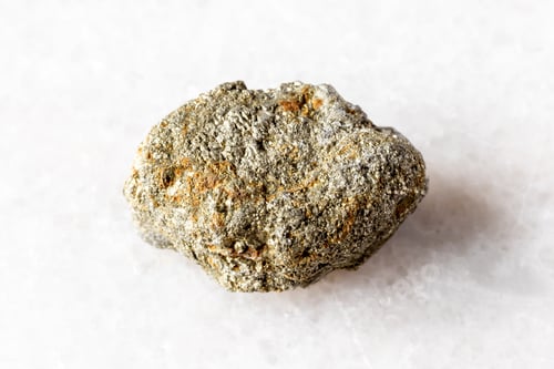 Preview: sample of unworked pyrite mineral on white marble