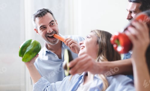 Preview: A group of smiling friends having fun together while preparing a vegan vegetable dinner