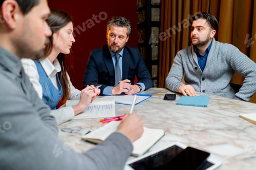 Preview: room with red walls office workers are sitting at head of the director discussing a business plan