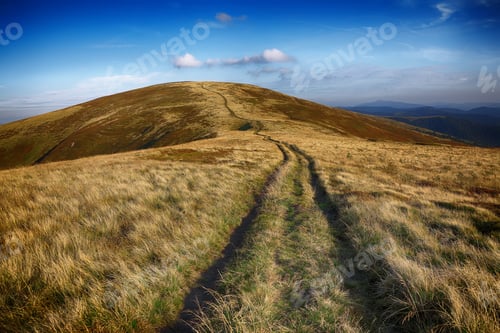 Preview: winding road through meadows of mountain range