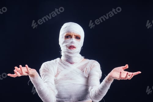 Preview: Glamorous mummy woman in bandages all over her body in studio black background