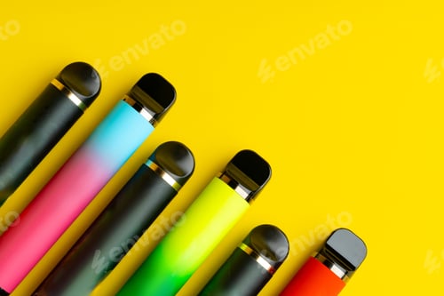 Preview: Colorful disposable electronic cigarettes on yellow background
