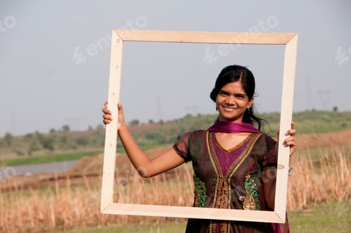 Preview: Young beautiful Indian girl with frame on nature background.