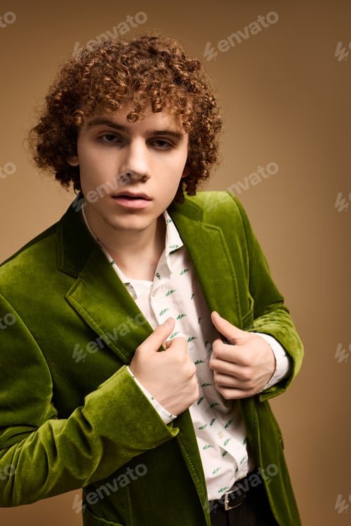 Preview: Curly teenage boy showcases vibrant green velvet blazer in stylish studio setting