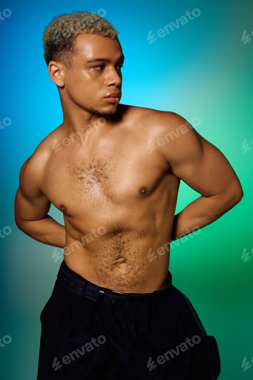 Preview: Muscular young man posing confidently in a vibrant studio setting