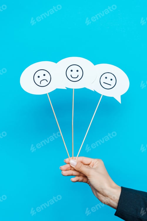 Preview: KYIV, UKRAINE - AUGUST 5, 2019: cropped view of woman holding set with emoticons on speech bubbles