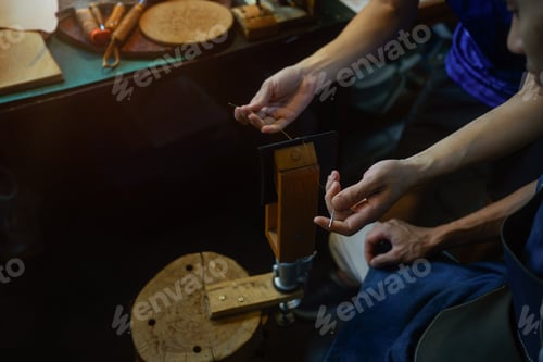 Preview: Craftsman creating product sewing leather with needle and thread in workshop