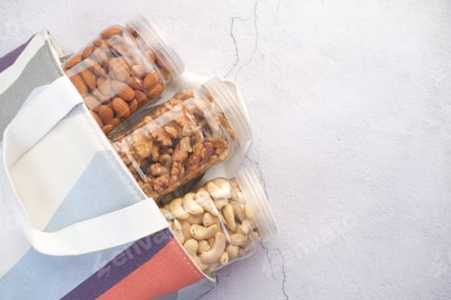 Preview: walnut , cashew nut and almond in a container on table