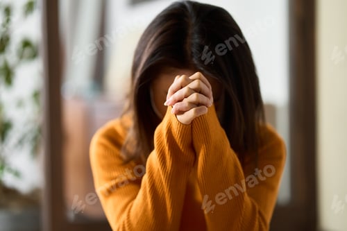 Preview: woman praying with her hands folded
