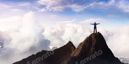 Preview: Adventurous Adult Man Hiker on top of Rocky Mountain with hands open