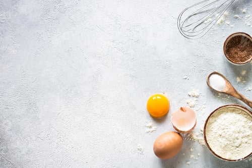Preview: Baking background ingredients. Flour, sugar, eggs and rolling pin at light stone table.