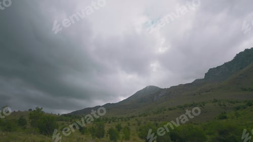 Preview: Mountain landscape with green slope on cloudy day. Action. Green slope of mountain on background of