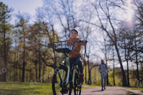 Visualização: Garotinho caucasiano andando de bicicleta com cesta