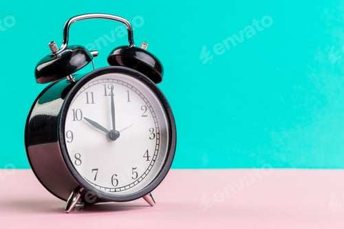 Preview: black vintage alarm clock on color background. High quality photo