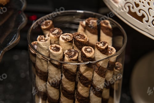 Preview: Closeup of chocolate wafer rolls in glass flask
