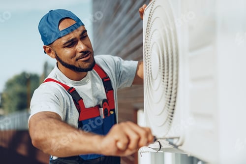 Preview: Young black man repairman checking an outside air conditioner unit