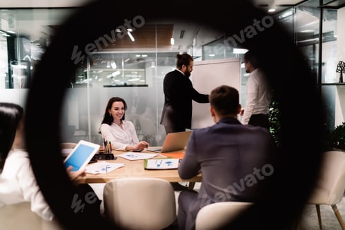 Preview: Group of colleagues discussing project in meeting room