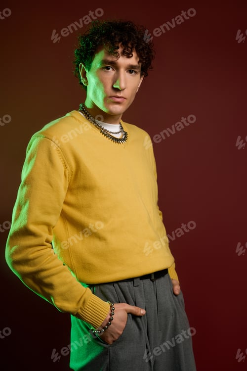 Preview: Stylish man radiates confidence in vibrant attire against a warm backdrop