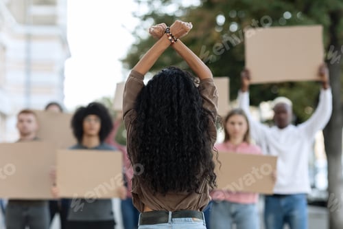 Preview: Unrecognizable long-haired woman leading group of protestors