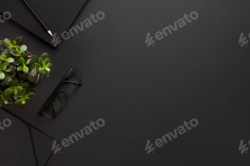 Preview: Top view of black office desk with notebook and supplies