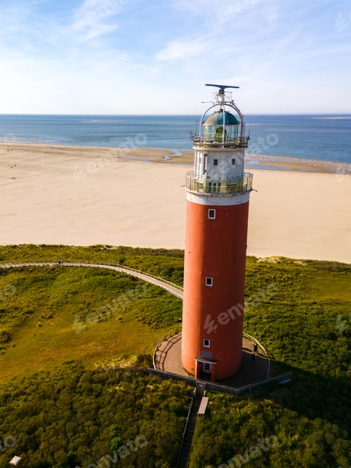 Preview: An aerial perspective of a historic lighthouse standing tall on the sandy shores of Texel
