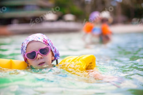 Preview: Adorable little girl and her mother with sister have fun in sea