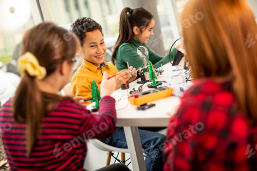 Preview: Happy kids programming electric toys and robots at robotics classroom