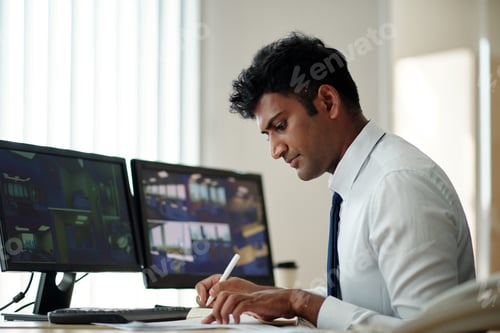 Adult Male Working at Desk with Computer Monitors
