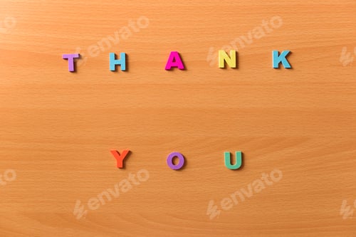 Preview: The words thank you in colored letters on a wooden background