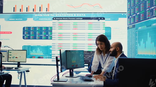Preview: Teammates examining statistics and infographics on computer in control room