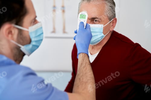 Preview: Senior Man Getting Temperature Checked by Medical Professional