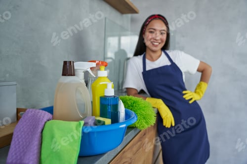 Preview: Close up of container full of cleaning products and equipment with young woman