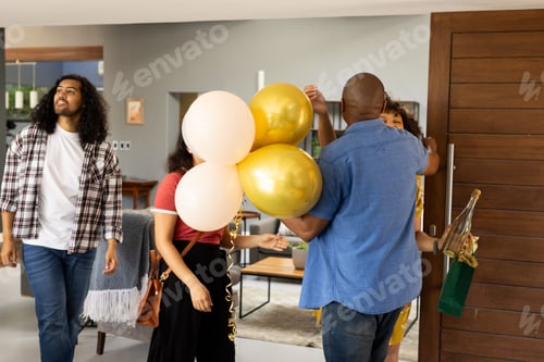 Preview: Friends arriving at home, greeting each other with balloons and champagne