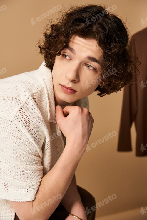Preview: Young man showcasing stylish summer fashion in a modern studio setting