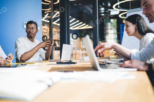 Preview: Wistful partners discussing business at workplace and using laptop