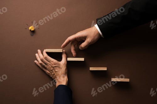 Preview: Hand of a businessman walking his fingers up the stairs supported by his female colleague