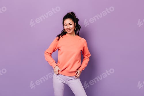 Preview: Positive asian girl standing with hands on hips. Confident japanese young woman smiling at camera.