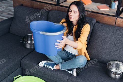 Preview: Wonderful young woman sitting on sofa with blue bucket