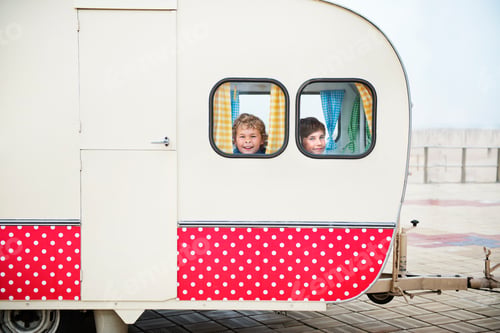 Preview: Boys looking through caravan windows, portrait