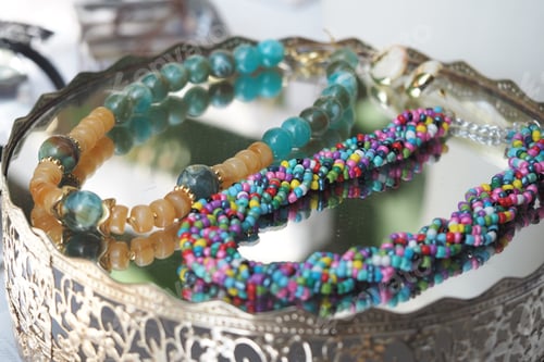 Preview: Colorful handmade jewelry displayed on a reflective surface