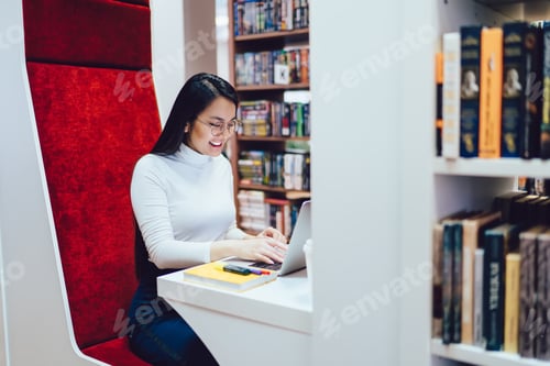 Preview: Female student studying at college library