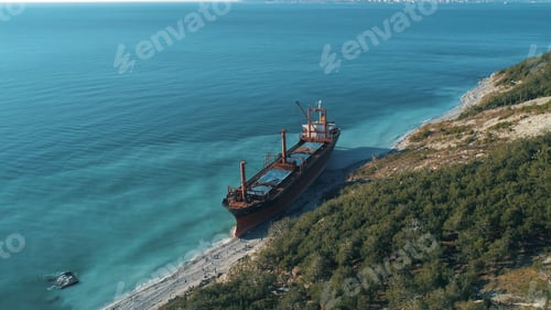 Preview: Aerial view of large cargo ship in still blue water near coastline. Shot. Sea transportations