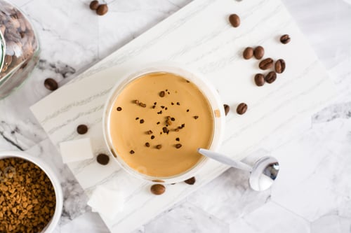 Preview: Dalgona coffee - trendy iced Korean coffee in a glass on the table. Social media drink. Top view