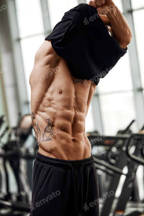 Preview: Portrait handsome and confident young Caucasian man at gym background. Face of brutal muscular sexy
