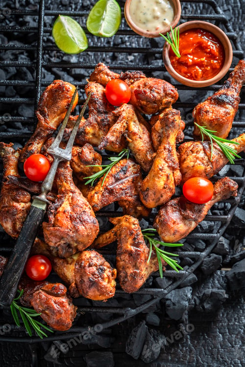 Preview: Tasty roasted chicken leg on black metal grill plate.