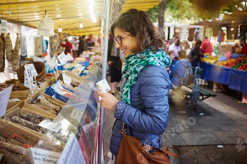 Preview: Young woman buying fresh food at market stall